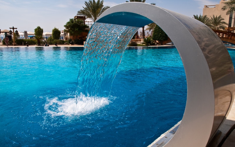 Metal water feature at an inground pool