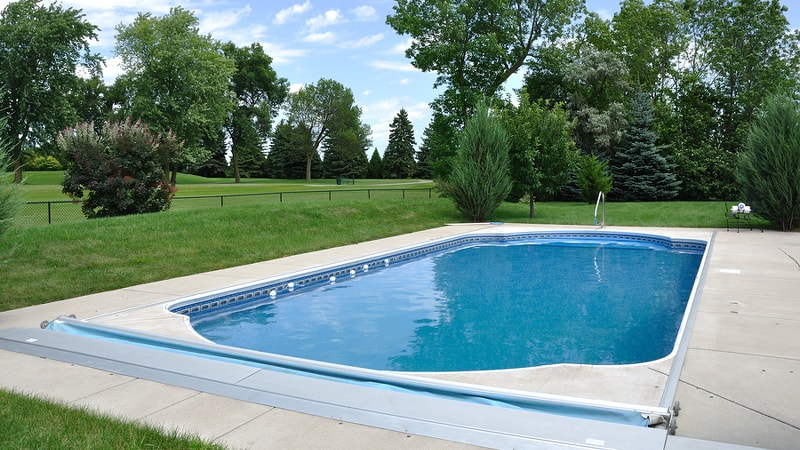 Inground pool surrounded by trees