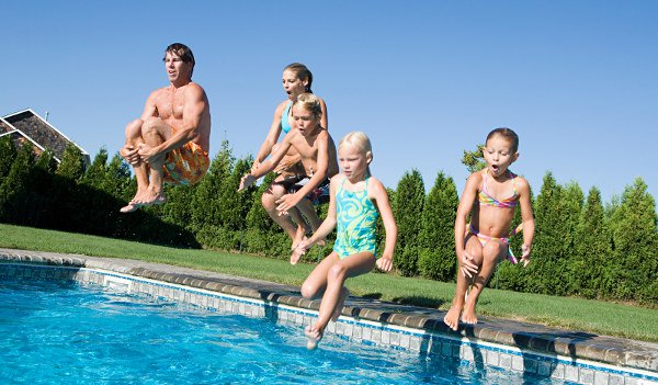 Five family members jumping into pool