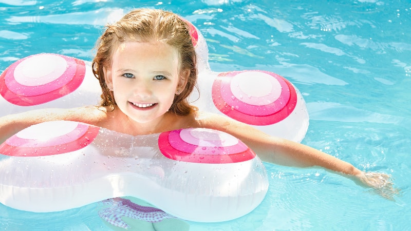 Little girl floating in an inflatable ring in a swimming pool