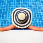 Woman relaxing in an inground swimming pool