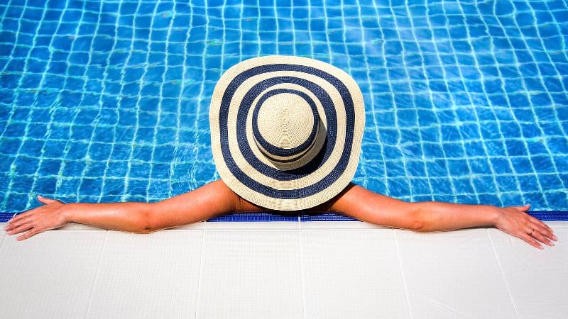 Woman relaxing in an inground swimming pool