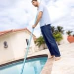 Man skimming a swimming pool