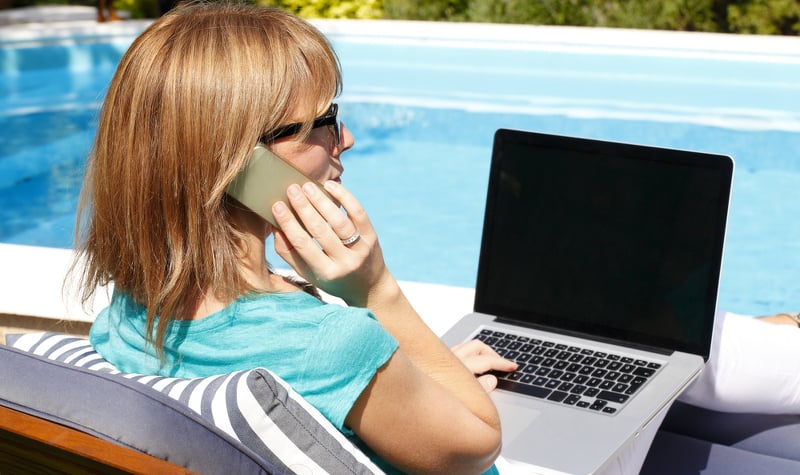 Woman sitting by the pool on the phone