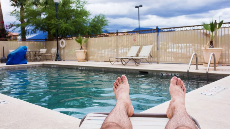Man kicking back enjoying backyard swimming pool
