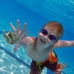 Boy reaching for dollar bill underwater