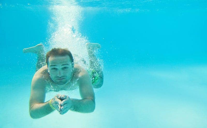 Underwater shot of a man who has just dived into an inground swimming pool