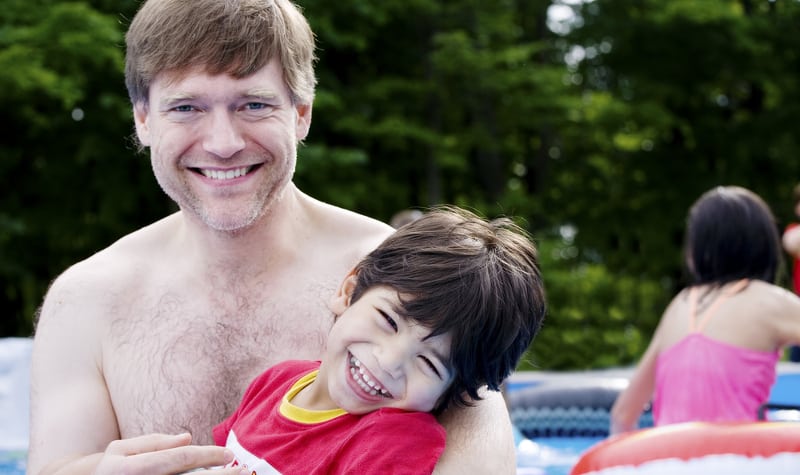 Man holding disabled boy in a swimming pool