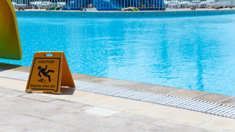 Slippery When Wet sign by a swimming pool