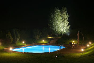 An inground swimming pool at night demonstrating various types of lighting