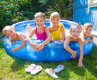 Four kids crowded into a kiddie blowup pool