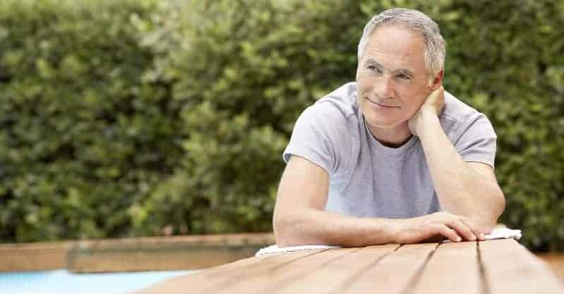 Man laying at edge of swimming pool