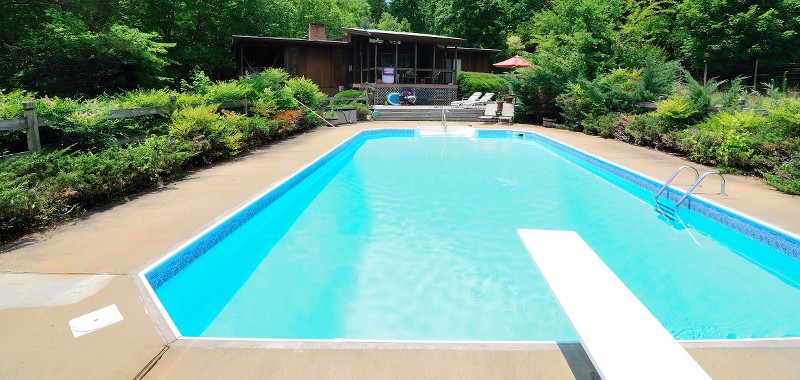 Rectangular pool with a diving board in the foreground