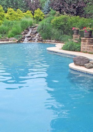 Large naturalistic inground pool with waterfall and beautiful landscaping.