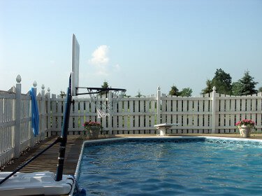 Picture of an inground swimming pool with a basketball hoop and diving board
