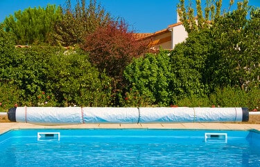 Closeup of an inground pool cover with manual reel