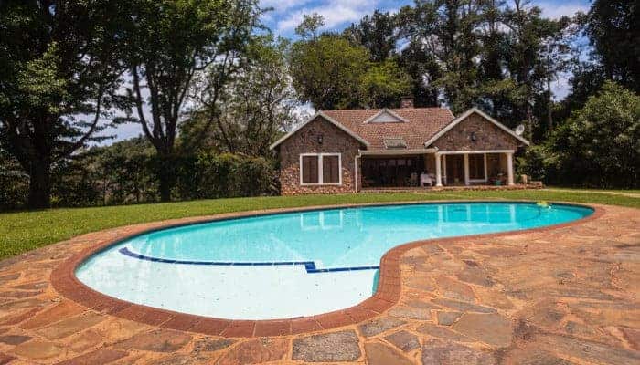 Small pool house next to an inground swimming pool