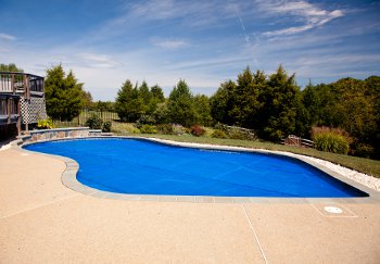 Bubble wrap solar pool cover floating on top of an inground swimming pool