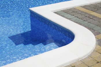 Section of an inground swimming pool illustrating poured concrete pool coping