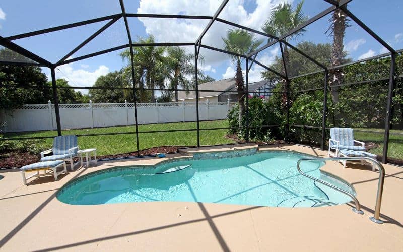 Inground pool covered by a screen enclosure