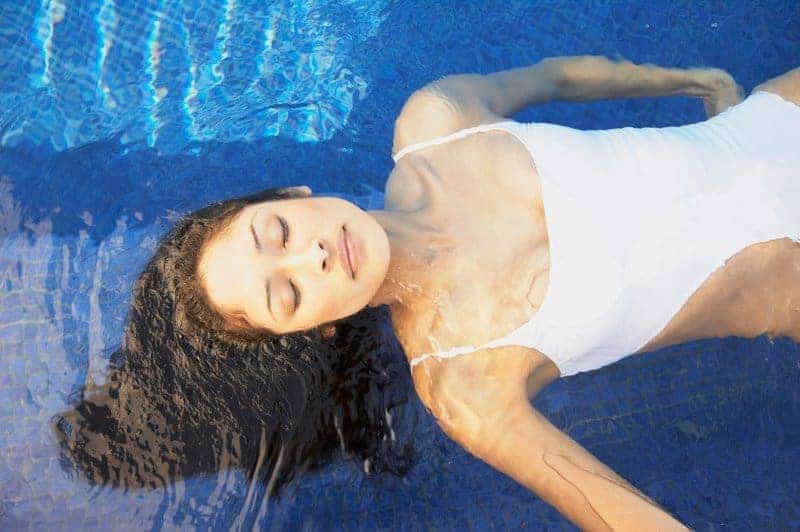 Woman lying back relaxing in a plunge pool