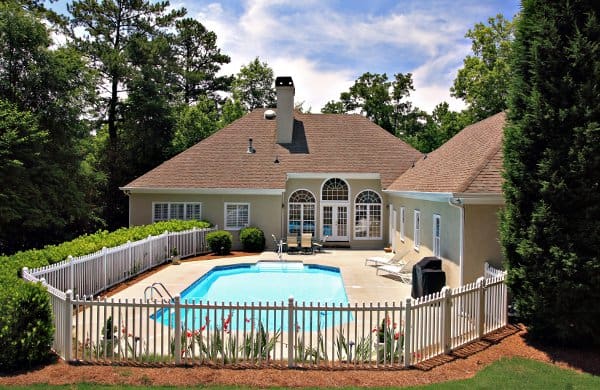 Picket fence surrounding a yard with an inground swimming pool