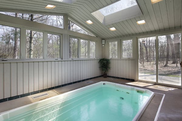 Indoor swimming pool in a standalone building with a sliding glass door