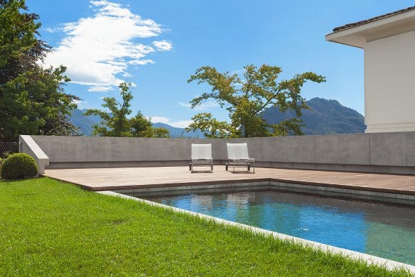 Inground swimming pool with grass on one side