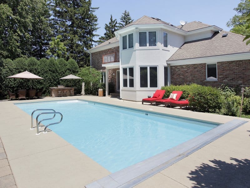 Grande piscine creusée rectangulaire construite près de la maison