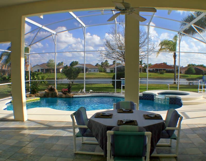 Pool lanai enclosure with view of a lake in the distance