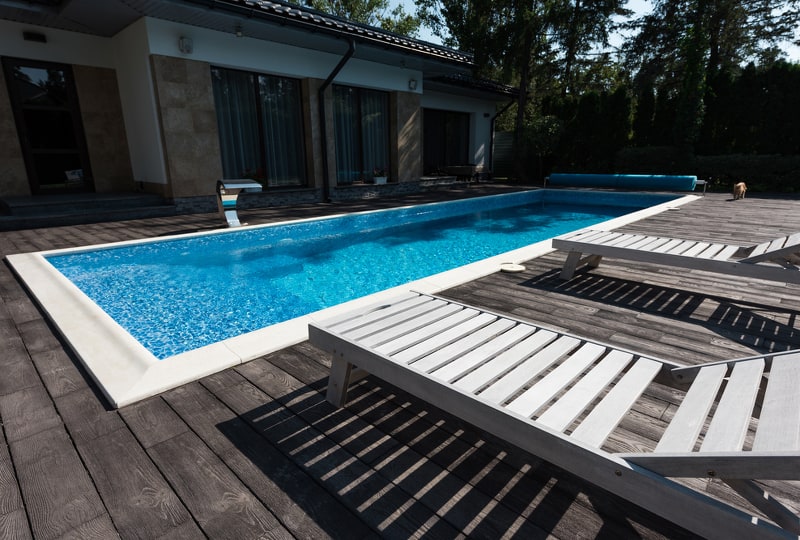 Rectangular inground pool with sun beds on the pool deck