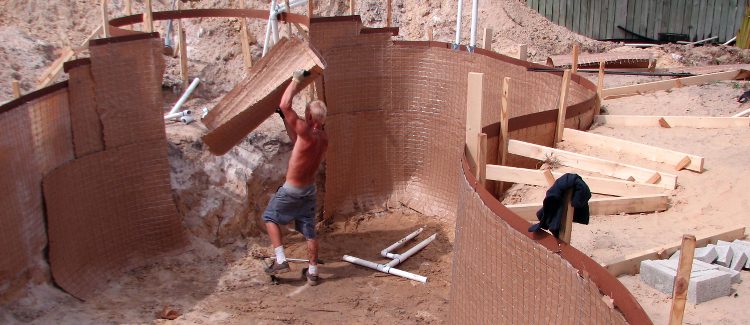 Picture of a man working on setting up the frame for an inground swimming pool