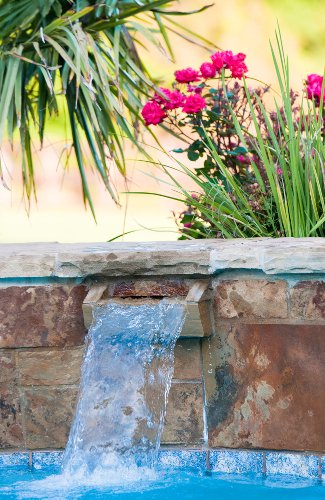 Stone waterfall on an inground swimming pool