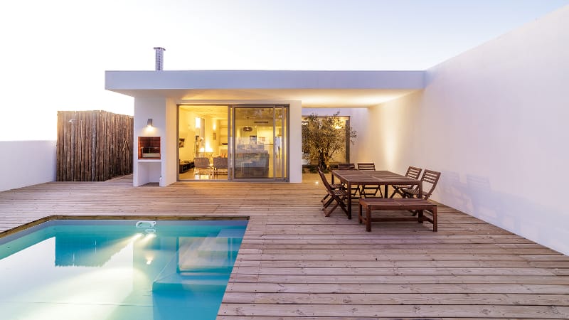 Photo of a small pool with a large wooden pool deck illustrating point on pool deck sizing