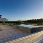 A semi inground swimming pool with wooden deck