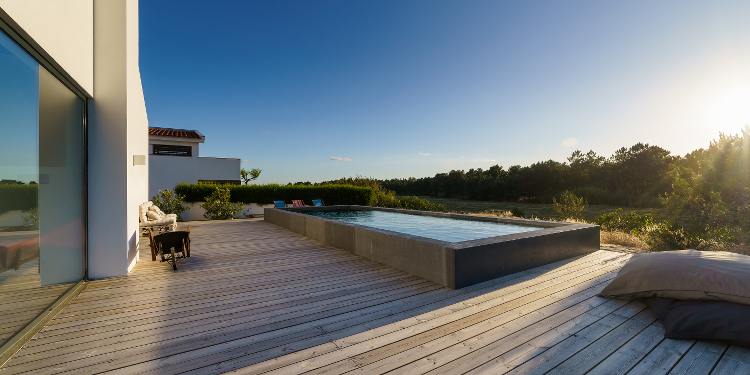 A semi inground swimming pool with wooden deck